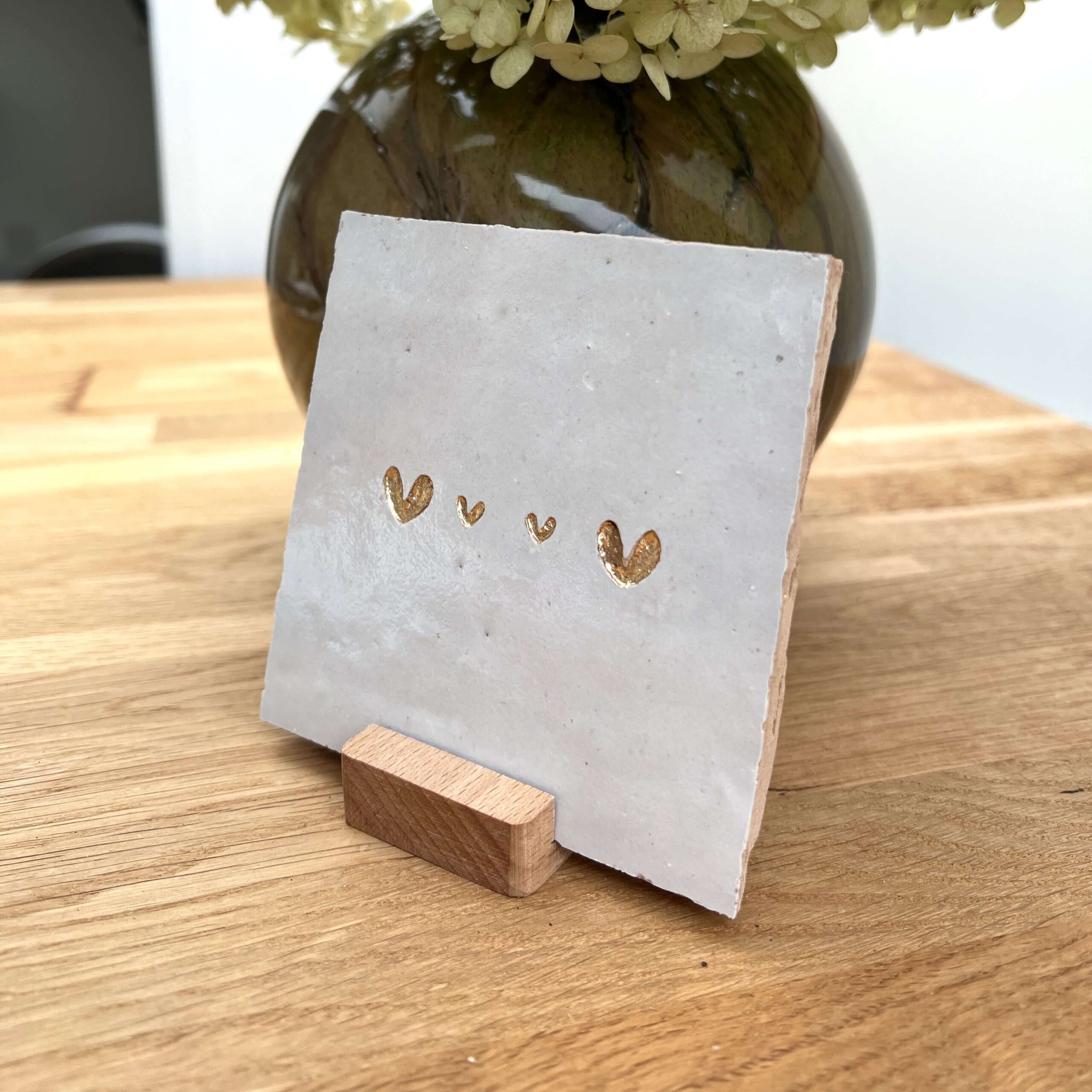 Gebroken wit - Tegeltje met een groot hartje twee kleine hartjes en een groot hartje Tegeltje met een groot hartje twee kleine hartjes en een groot hartje