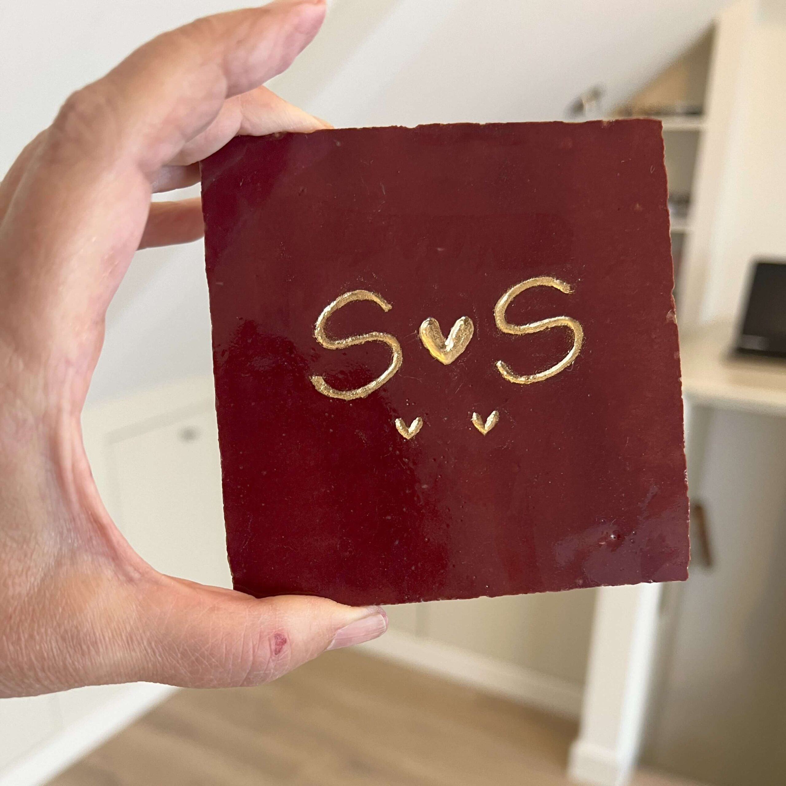 Tegeltje met een letter een hartje een letter en twee kleine hartjes