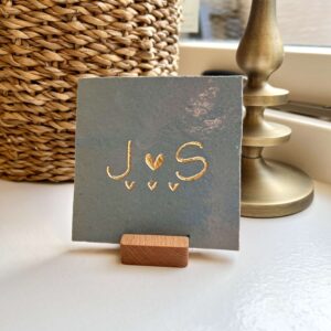 Tegeltje met een letter een hartje een letter en drie kleine hartjes