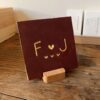 Tegeltje met een letter een hartje een letter en drie kleine hartjes